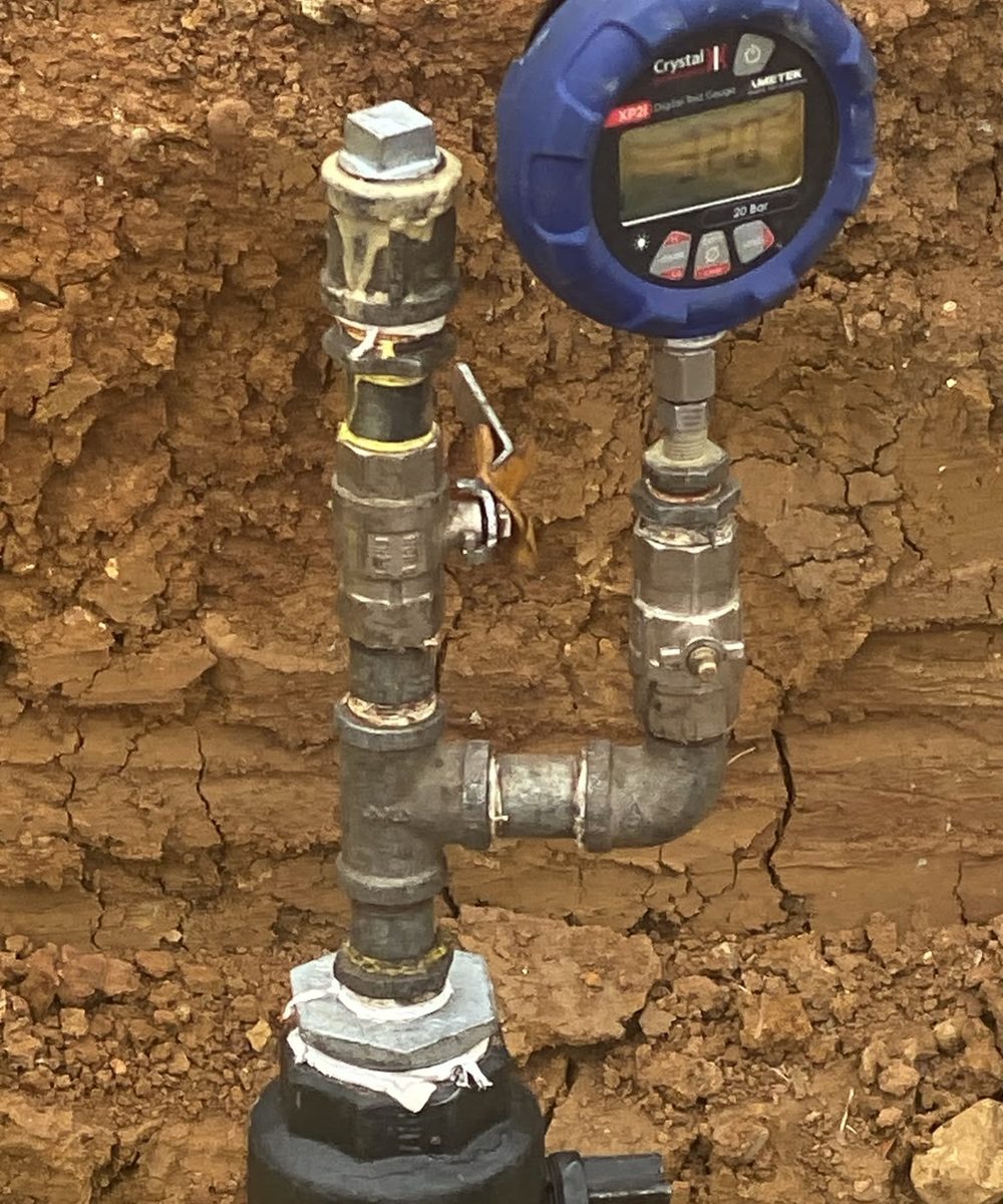 Digital pressure gauge on a test assembly fitted to a new PE main